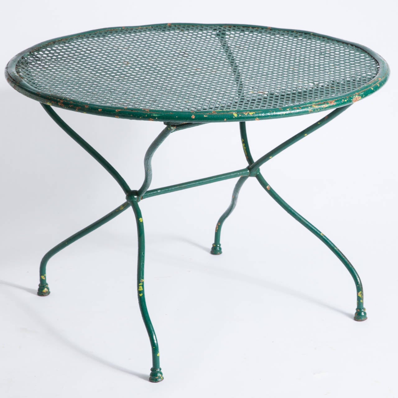 This French early 20th century antique garden set consists of a round table with four matching chairs. It is in very good condition. The green paint reveals bits of previous paint underneath giving it a wonderful patina. The chairs with unusual
