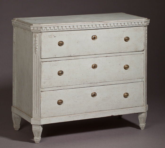 A Swedish, late Gustavian, grey painted Chest of Drawers with beautiful dental molding and a flower spray carving on each corner.  The top drawer has three small 