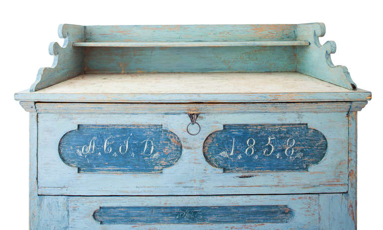 A Swedish secretary in spectacular blue original paint with contrasting raised  panels on the doors and top. It is signed with the initials of the owner and dated 1858. The two doors on the bottom open to reveal shelves and the front panels open to