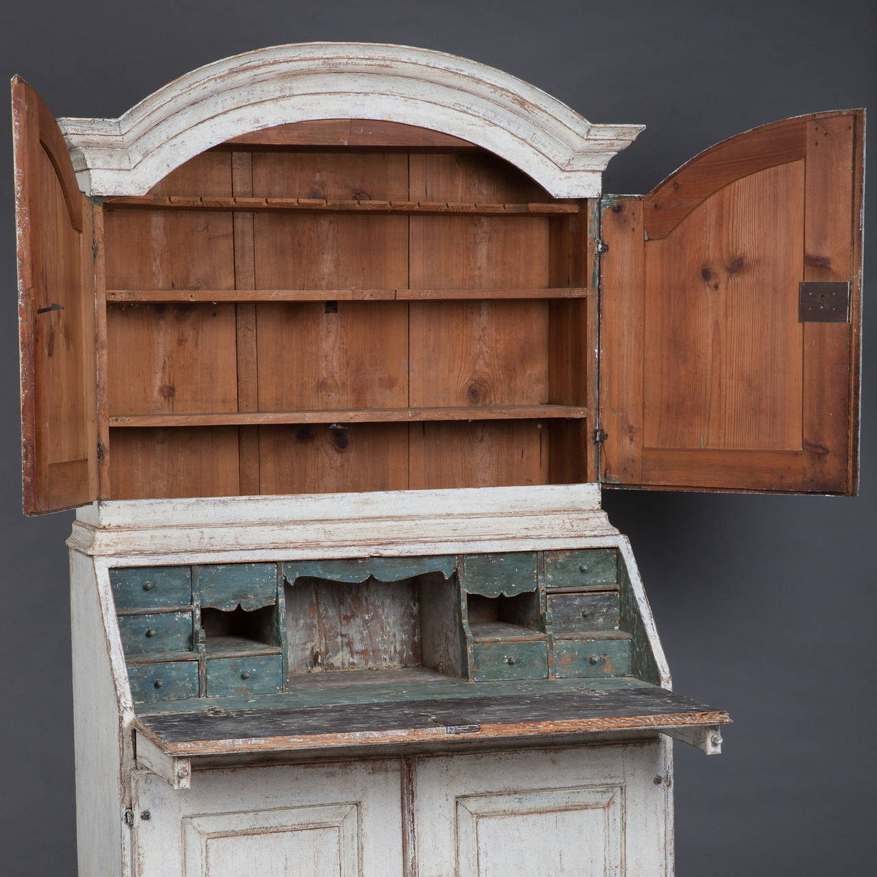 This Rococo period secretary is a wonderful size to fit in a bedroom or library. It has an old white paint exterior surface and original green paint on the interior where there are 11 small drawers with three of them being hidden or secret. Three
