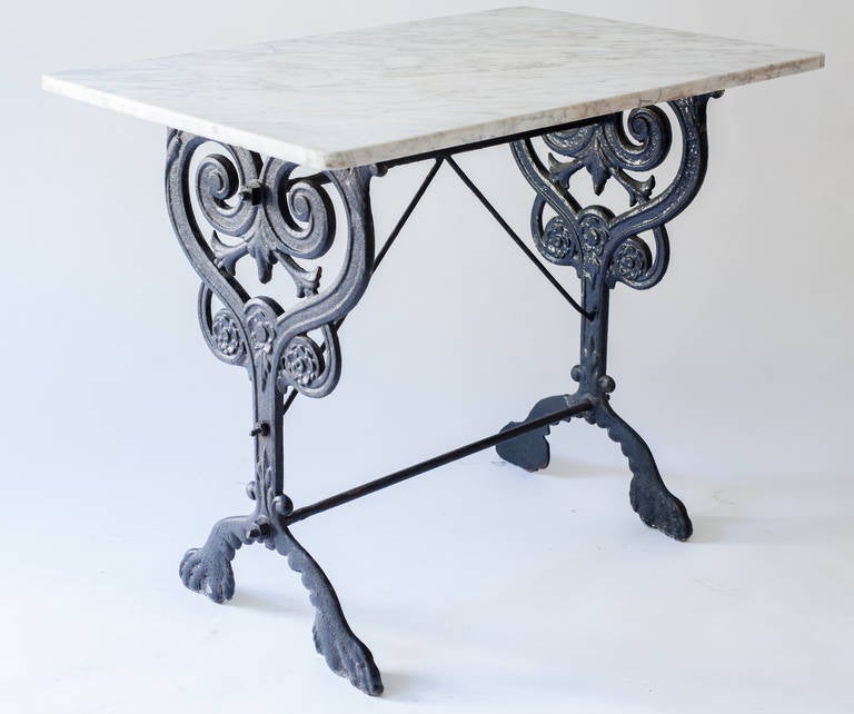 A very interesting French marble-top console or bistro table with an elegant elaborately designed base and lovely marble top. One foot has been replaced and is simpler in design than the other three, although it blends well. This piece dates to the