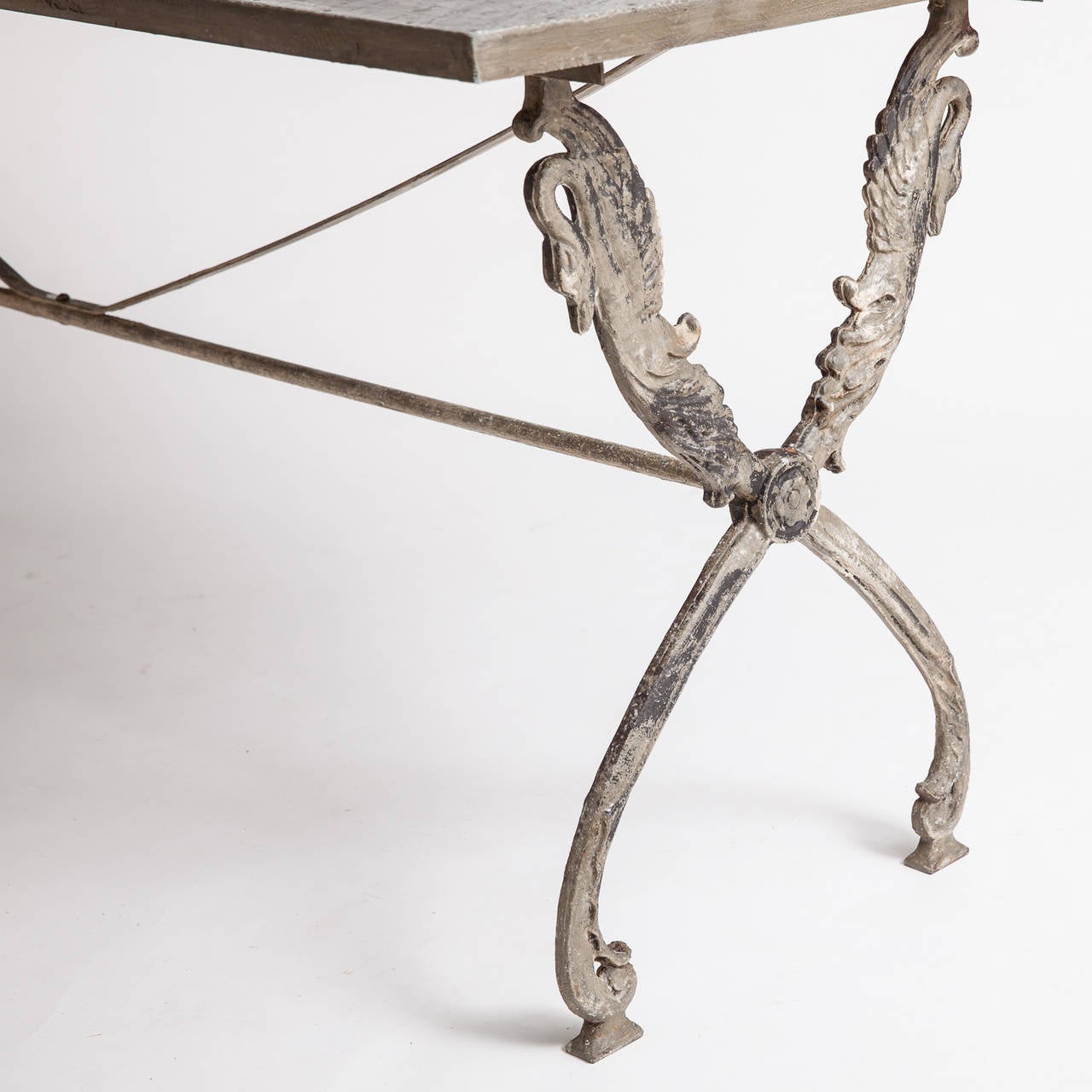An elegant base depicting carved swans in old greyish paint and an extra long well proportioned top, make this a wonderful table for dining or as a desk with lots of room. The wooden top is covered with hammered zinc, which gives it a terrific look.