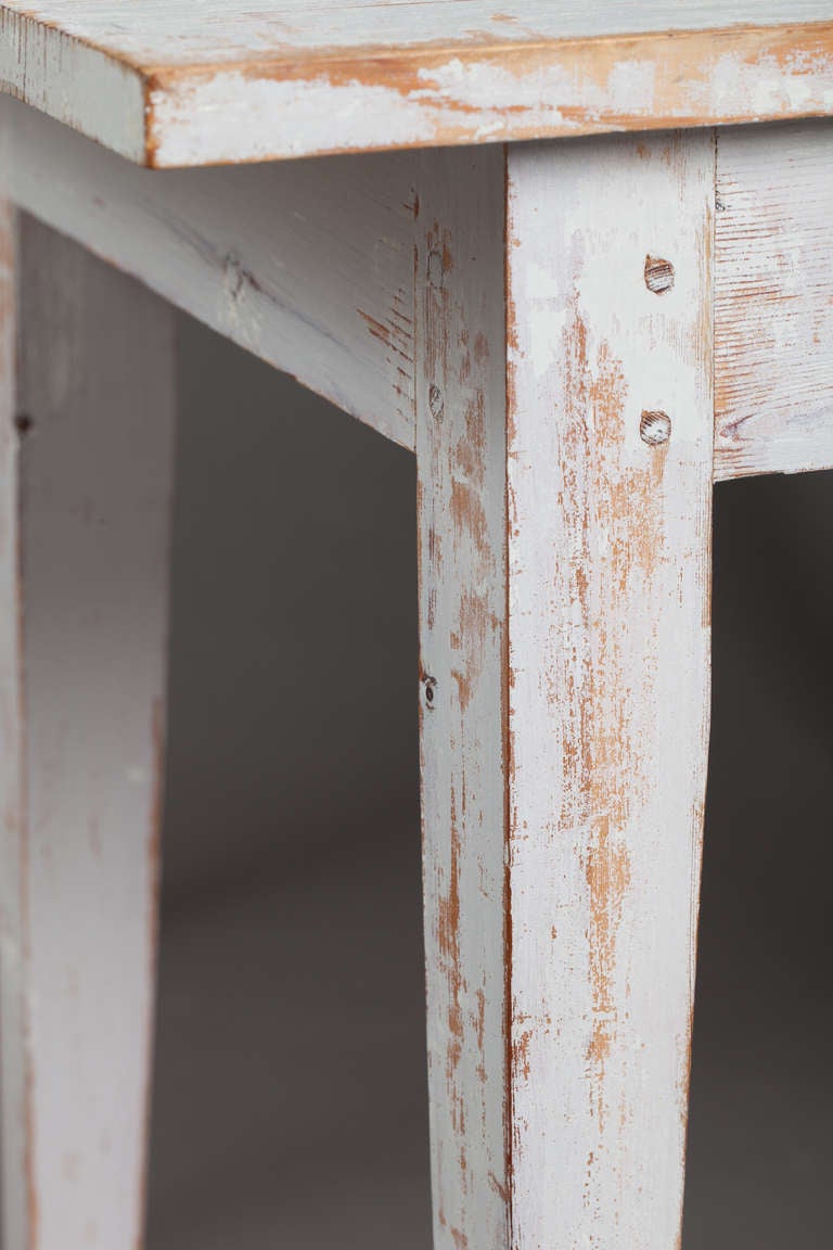 A Swedish Gustavian style side table with traces of original white paint. the table has slim tapered legs and a sleek modern look. It would make great bedside table. Sweden circa 1880.