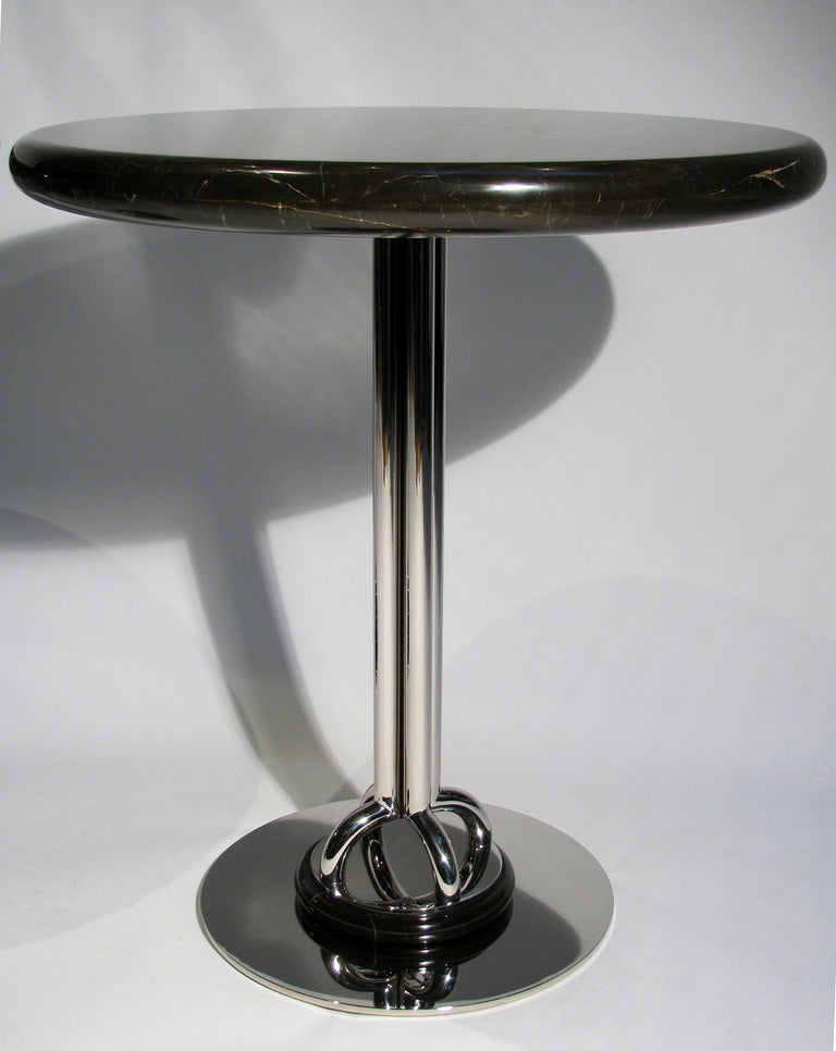 A rare and important pair of marble and highly polished steel drinks or side tables by Nicos Zographos. The pedestal base is highly polished steel with a round marble disk at the base and marble top. The quality of the workmanship is reflective on