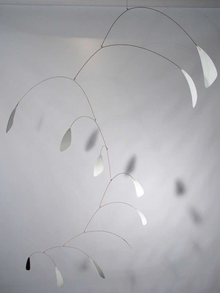 A large kinetic mobile in the manner of Alexander Calder (American 1898-1976). Mixed media, unsigned. White enamel petals with the end petal black.