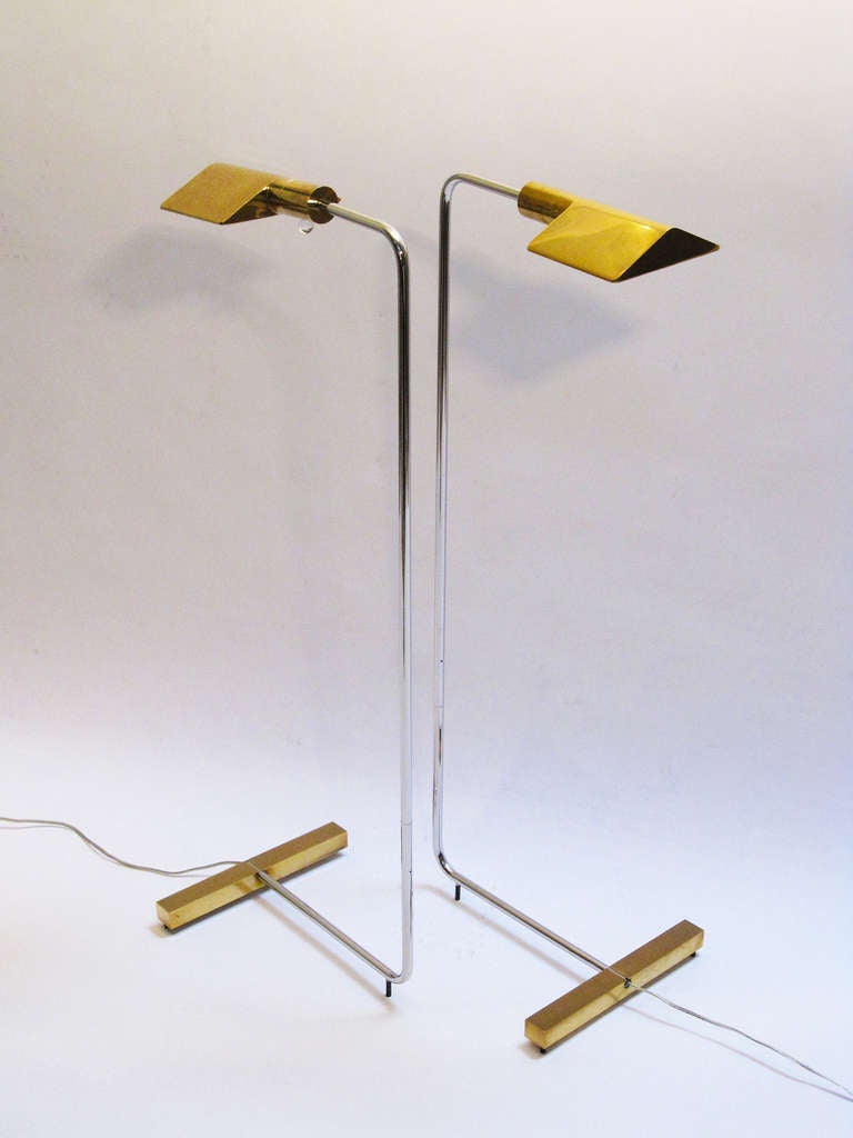 A minimalist pair of adjustable reading lamps consisting of a rotating pyramid brass shades with lucite ball switches, supported by a thin polished chromed steel tubular pole with one pivot point that allows rotation of almost 360 degrees, and