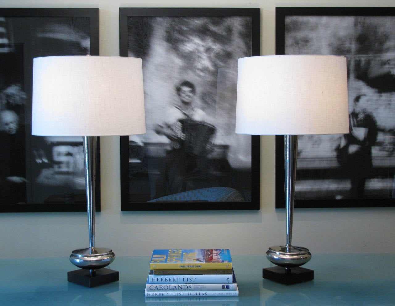 A pair of chic modernist style table lamps of nickel with walnut bases. Three-way switch at socket. Overall height to finial is 36 inches, 27 inches socket height. Linen drum shades are not included.