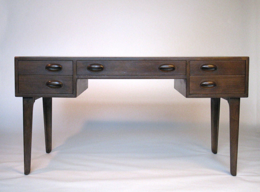An early Edward Wormley for Dunbar walnut and leather desk. Branded with DUNBAR underside, this desk is a fine example of Wormley's early work. Solid walnut wood with five drawers in front, center drawer is quite deep, and opens with a locking