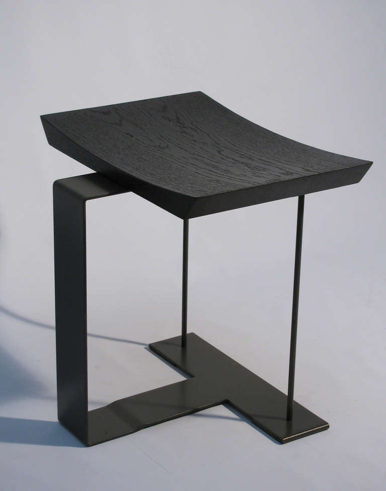 A steel frame and oak stool by Pierre Chareau, (1883-1950)  Paris, France. Designed in 1927, later re-issue 1984. The frame is a lacquered anthracite steel with a cerused black oak seat.