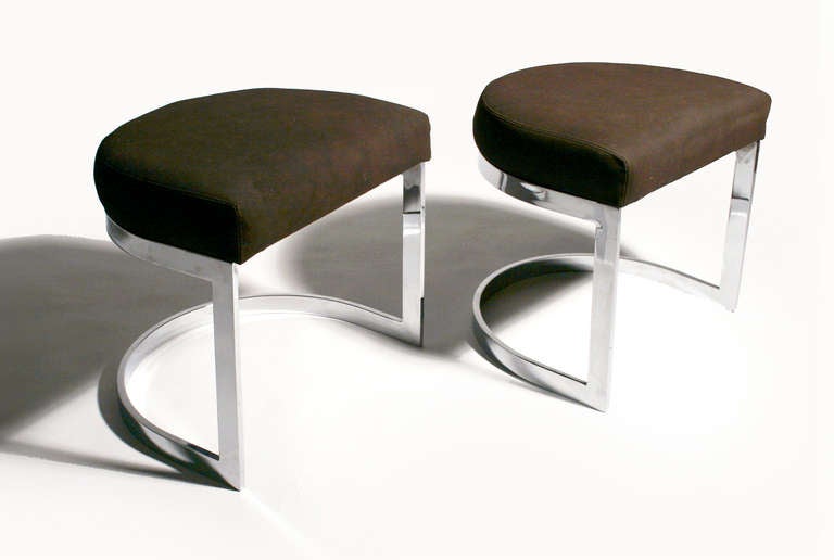 A pair of chrome cantilevered ottomans or stools with brown suede upholstery and tan stitching. Attributed to Milo Baughman. Priced per pair.