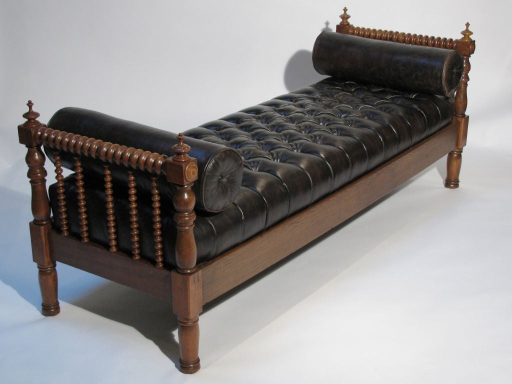 A gorgeous long and narrow tufted leather and walnut daybed or bench. Circa late 19th Century to early 20th. The tufted leather is in a dark espresso color, with loose bolster pillows.
