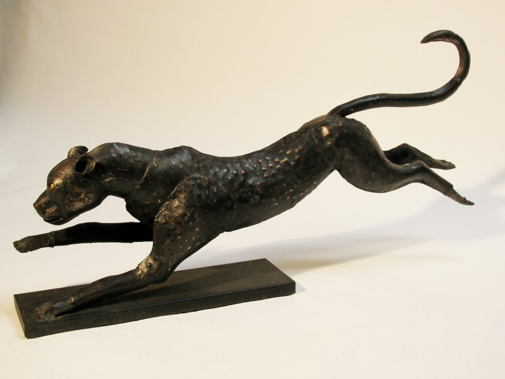 A pair of large scale metal sculptures of running cheetahs, each comprised of welded metal in a brutalist style, with black, rust,and bronze finish.