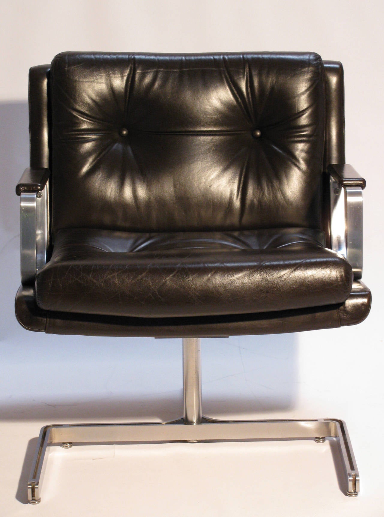 A modernist pair of French lounge chairs by Raphael Raffel, better known as Raphael, (1912-2000). Sumptuous espresso leather on satin-finished chrome wishbone base, with canted arms and leather pads.