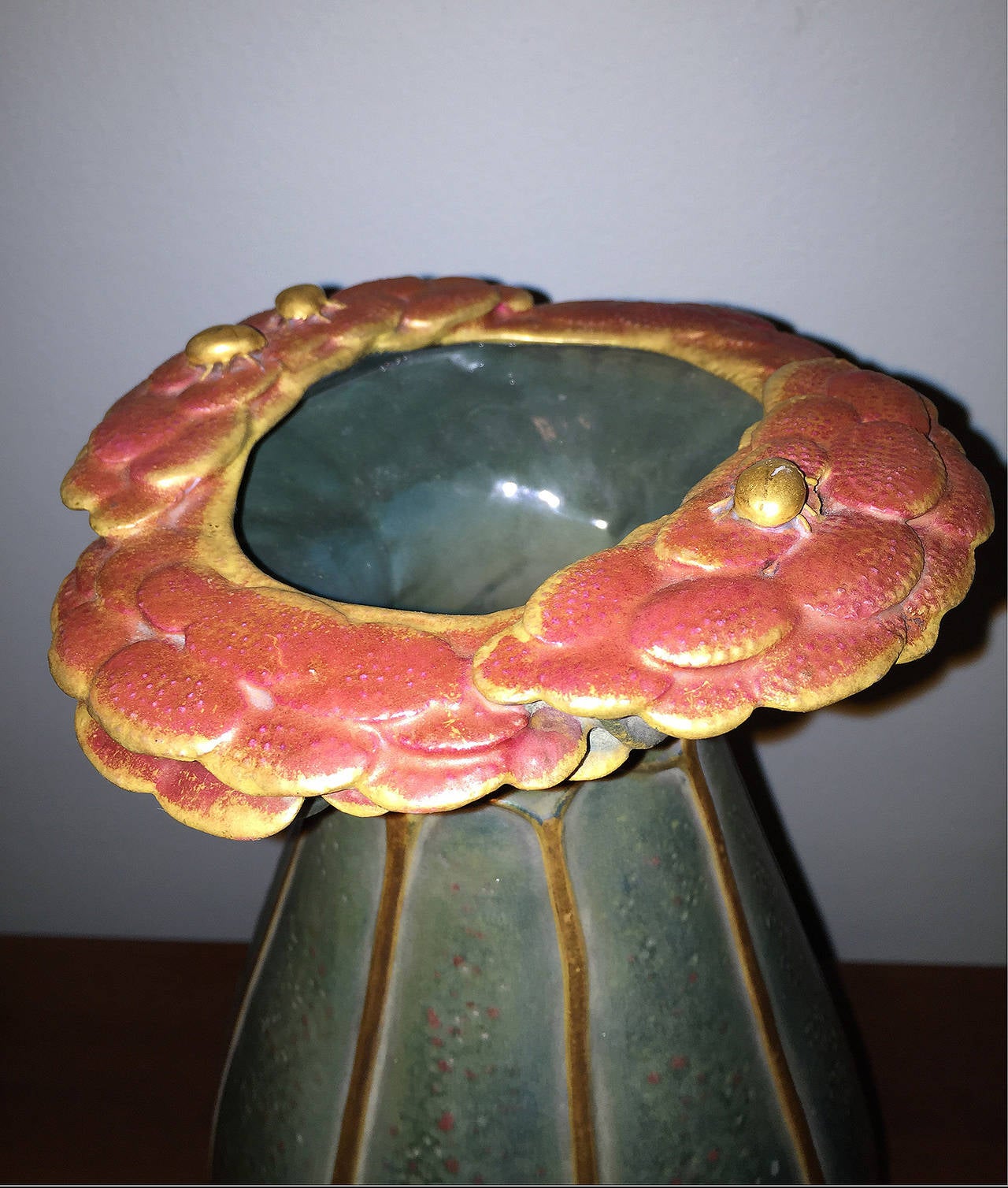 A highly desirable and rare (with red) Amphora hard earthenware and iridescent vase with relief leaves and stems. On the mouth is a wreath of umbellates (flowers with pedicels that form a flat cluster, carrot family) with small gold beetles. Hand