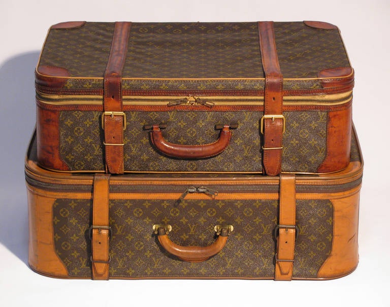 A pair of vintage Louis Vuitton stacking luggage trunks with the monogram and leather trim. Measurements of the large trunk are: 29.5 x 21 x 10 inches. Small: 27 x 18.5 x 9 inches. Overall dimensions listed below are both trunks when stacked