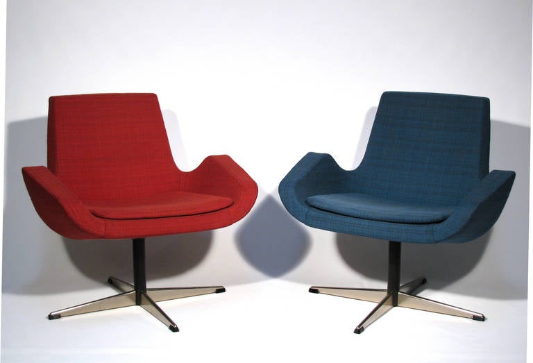 A pair of sleek and angular design Scandinavian swivel chairs, upholstered in original wool twill, one in red and the other in blue.