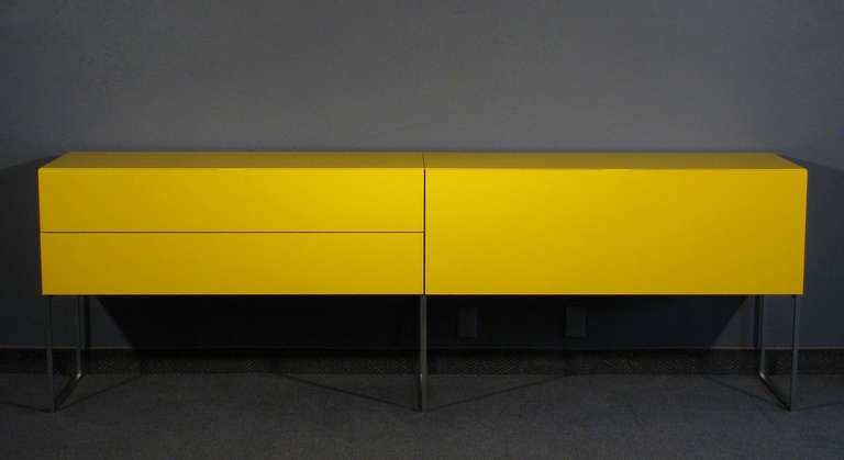 A credenza by Piero Lissoni for Porro, Italy. This long sleek credenza features two long divided drawers and one drop front door for storage. The whole; resting on a brushed steel open base. The credenza is a high quality piece inside and out and