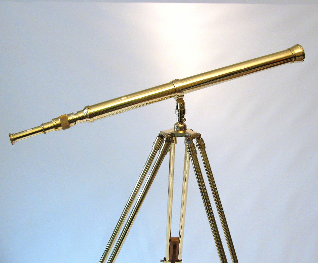 A wonderful antique solid brass telescope on brass and wood adjustable tripod, terminating to brass ball feet. No maker's marks were found however, the screws and bolts prelude standard or metric threading. The complete restoration of the brass and