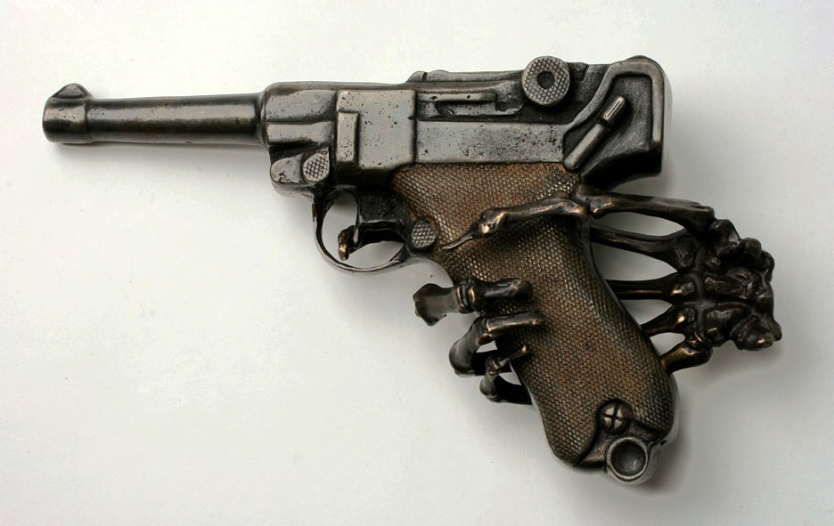 A provocative sculpture in two pieces. The life size bronze hand holds a solid cast iron Luger.
The pistol has a solid barrel and is not operable.