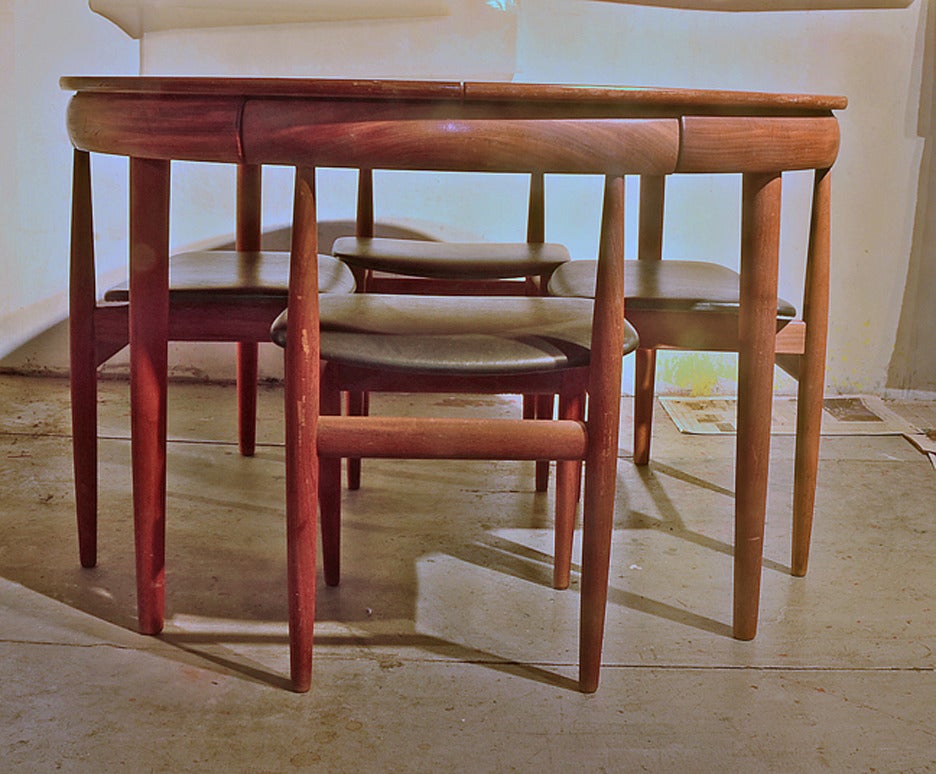 Classic Olsen design for fitted round teak table and 4 chairs.  This set has the hard-to-find 4-legged chair. Opens to accommodate one leaf that is stored within the table when not in use.