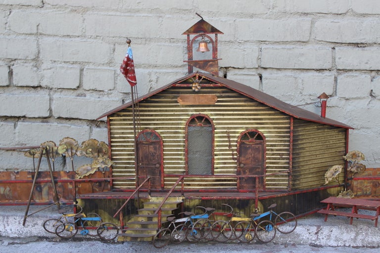 Mid-Century painted wall sculpture of schoolhouse.   This wall sculpture includes intricate details of schoolhouse, bikes, picnic benches, school bell, and American flag. The piece is signed C. Jere.