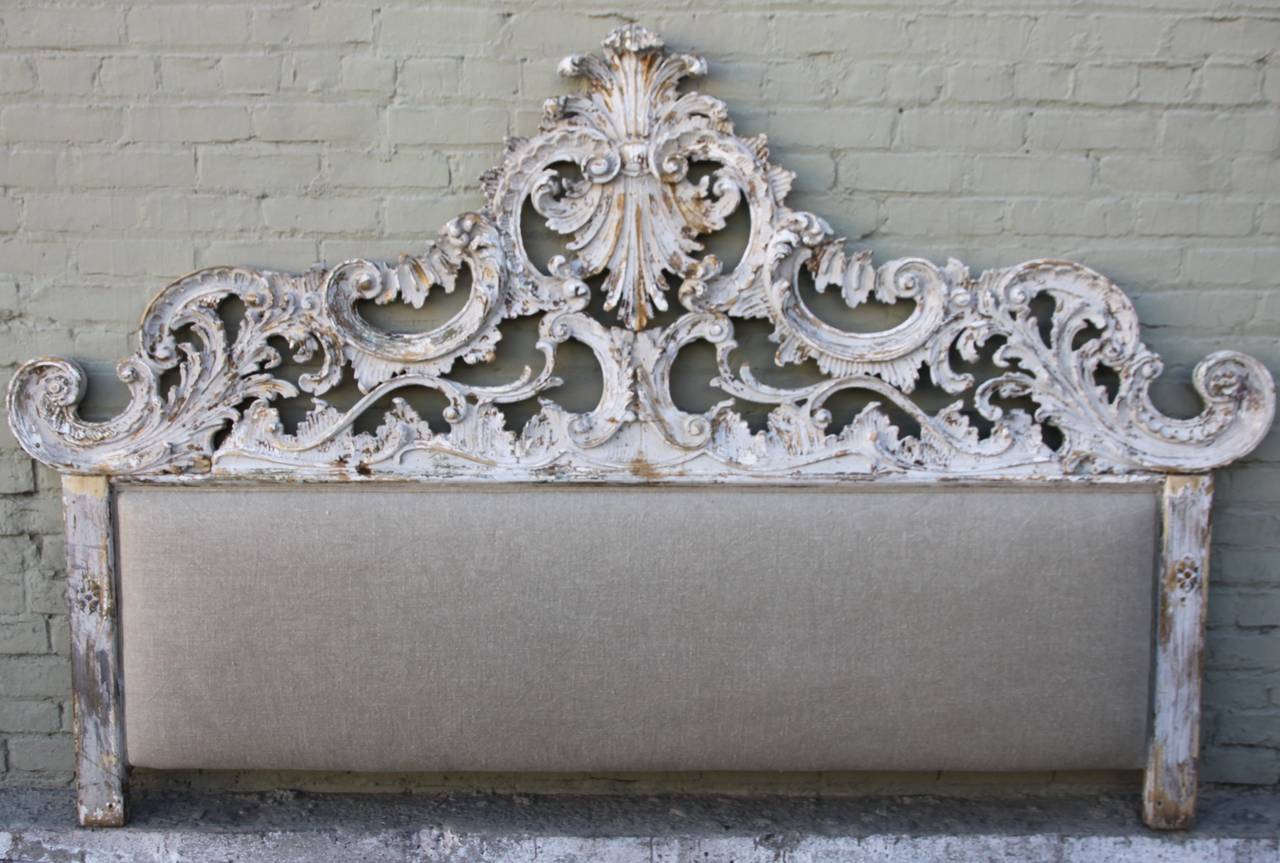 Monumental Italian carved painted headboard newly upholstered in burlap textile.