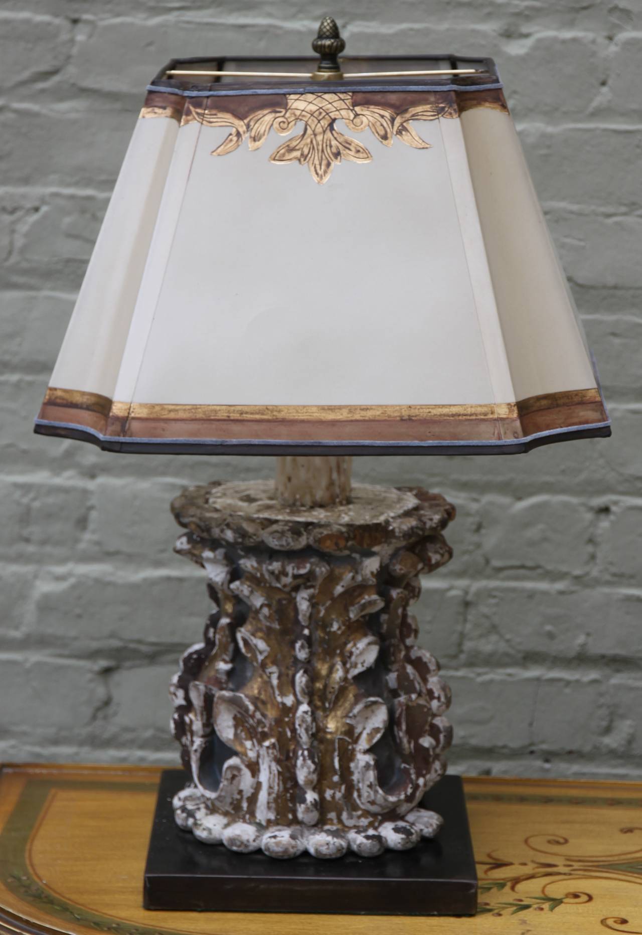 Pair of Italian carved painted and parcel-gilt architectural pieces mounted on steel bases and wired into lamps. Crowned with hand-painted parchment shades.