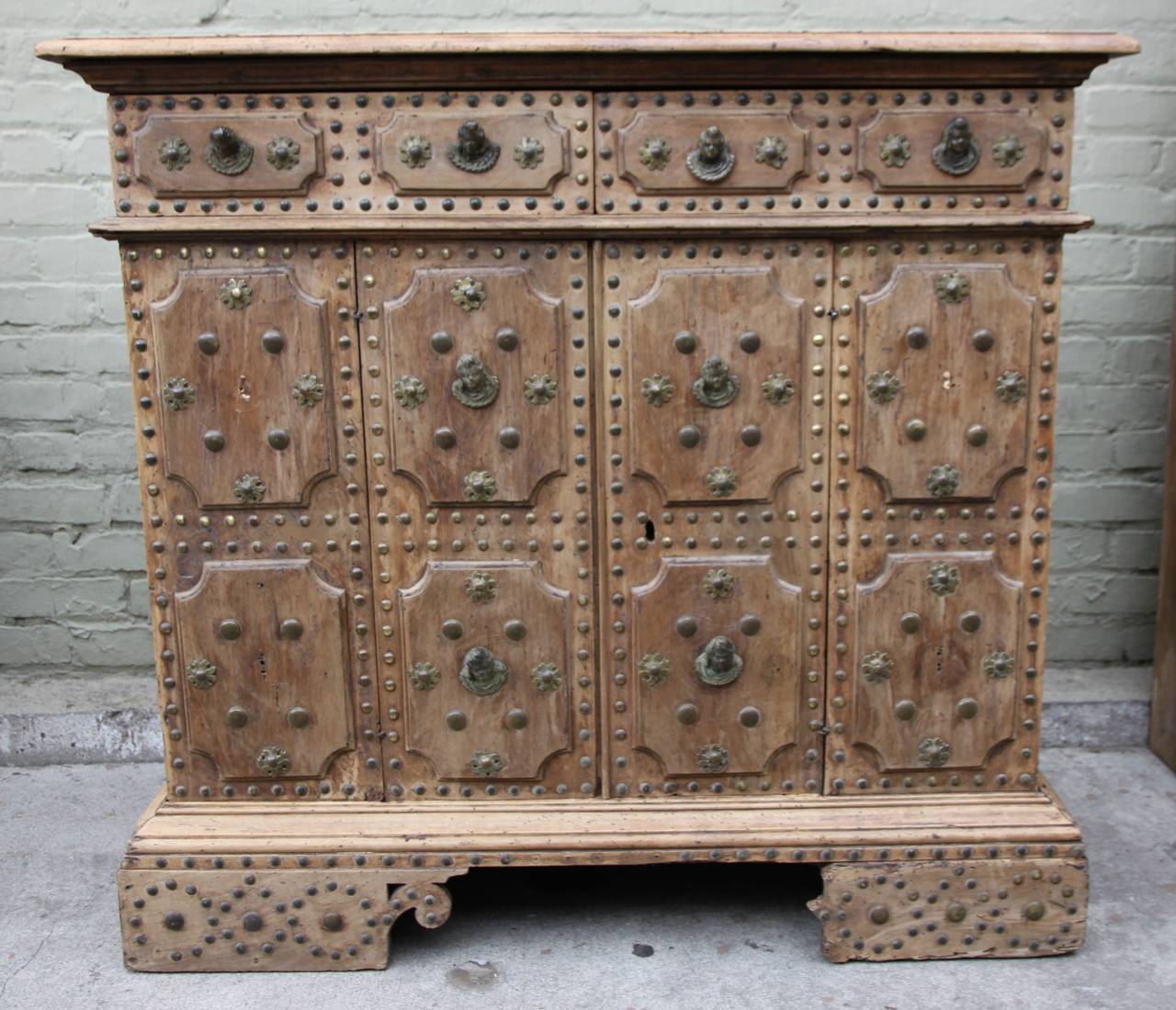 18th century Spanish studded buffet with bronze figural hardware. The cabinet has two drawers and two doors with ample storage.