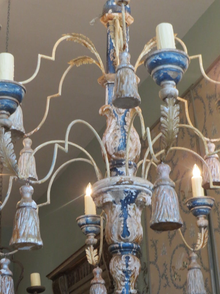 Monumental carved wood, iron, & painted chandelier with large tassels hanging from every arm.  The chandelier is painted in blue & silver with gold highlights.  It has been completely rewired and is in working condition.