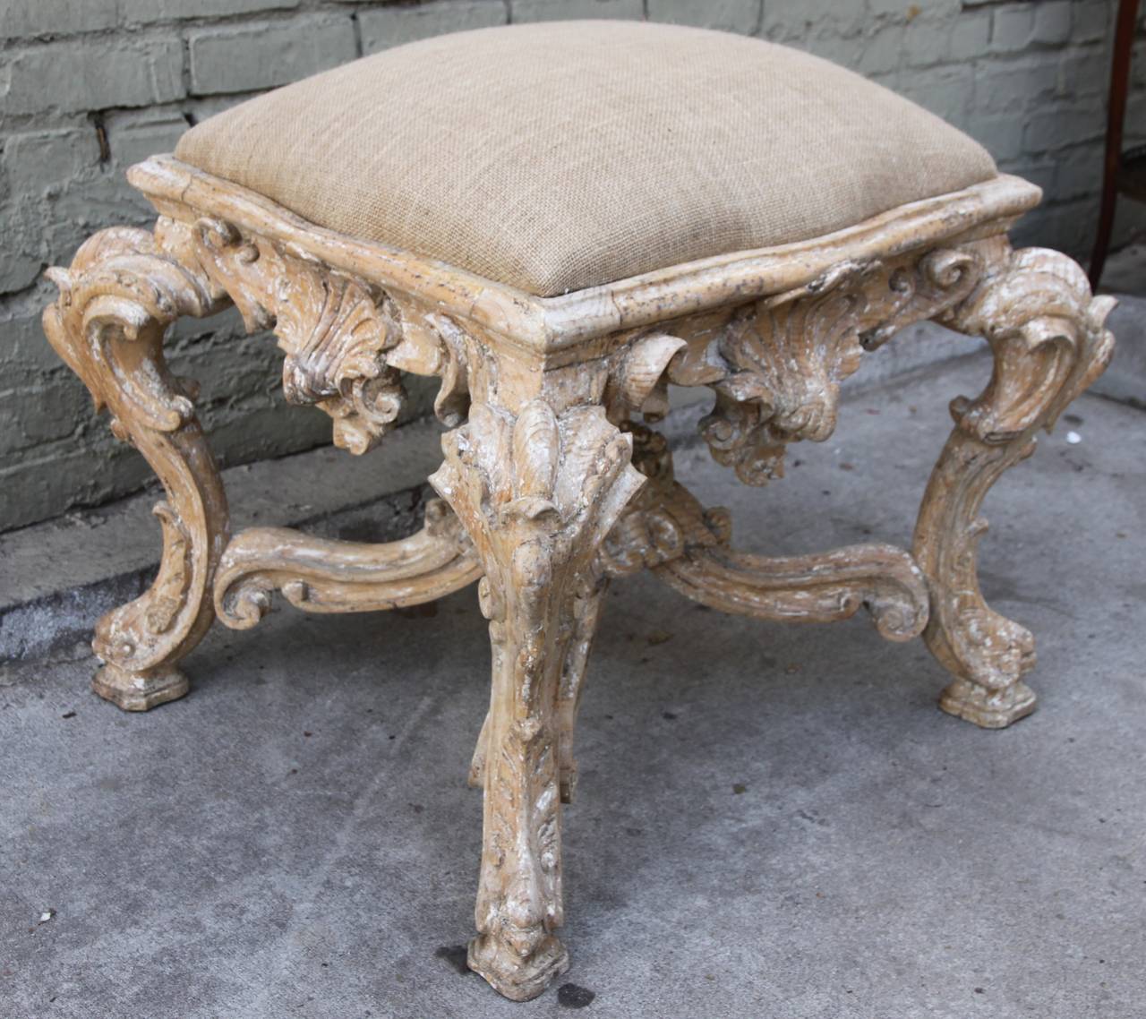 French carved Louis XV style bench standing on four cabriole legs with shell design and bottom stretcher. Newly upholstered in burlap textile.