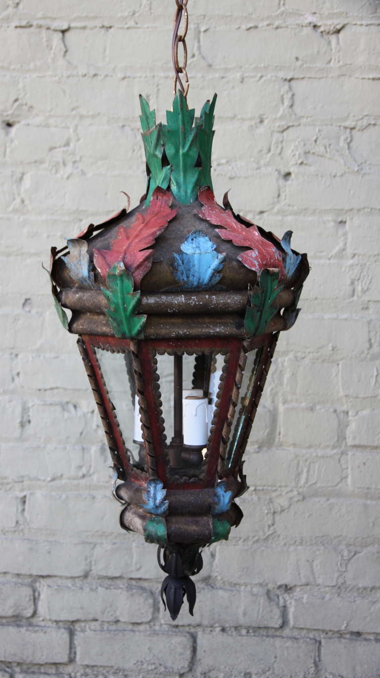 Pair of Spanish painted tole lantern with three candelabra size sockets. Painted accents in red, blue, & green. Newly wired and ready to install with chain and canopy.