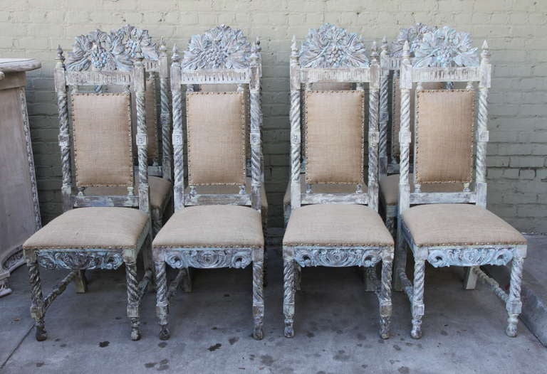 Set of (8) Spanish carved painted dining chairs with new burlap upholstery with self welt and nail head trim detail.