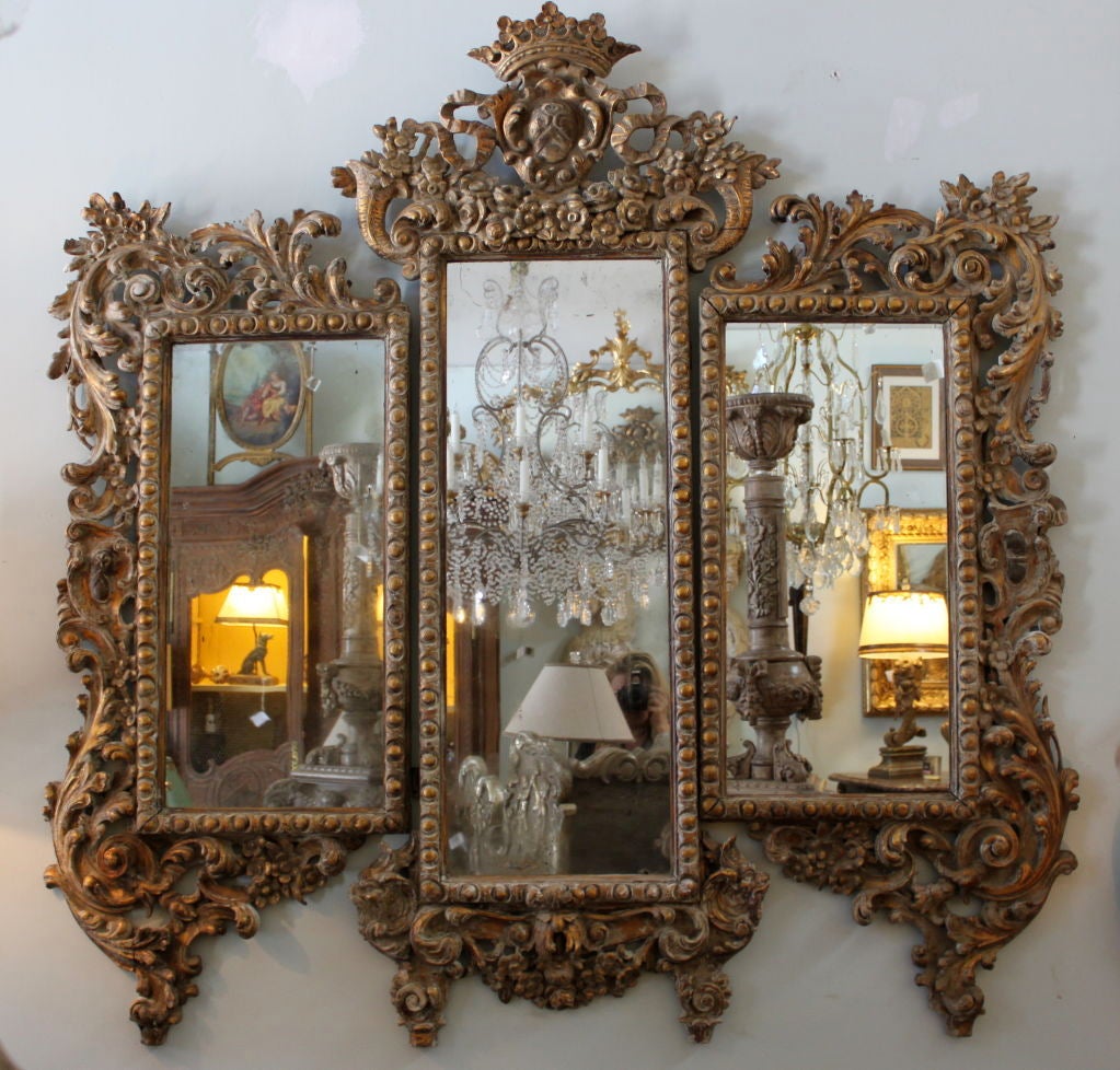 Carved Painted & parcel gilt Italian Rococo style mirror/screen.  There is a crown & crest at the top of the mirror flanked by cornucopias and garlands of flowers.  The frame is embellished with swirling acanthus leaves throughout.  The panels can