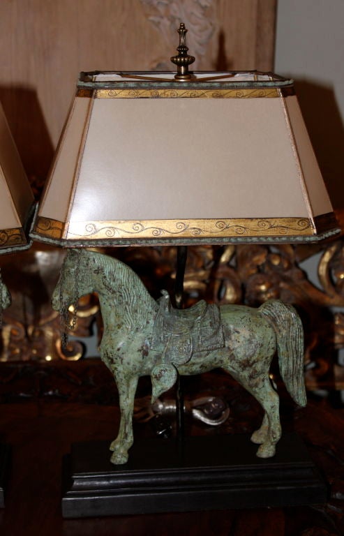 Pair of opposing bronze horse lamps with custom painted parchment lamp shades c. 1900's.