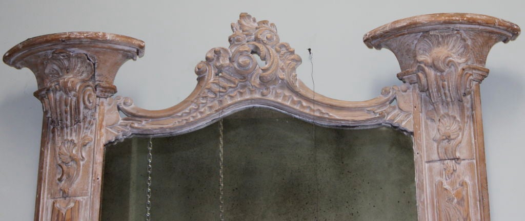 Carved Italian architectural mirror with a washed finish. The mirror also has a great antique patina. Notice the cartouches and acanthus leaves as well as the shell motifs at the top of the columns.