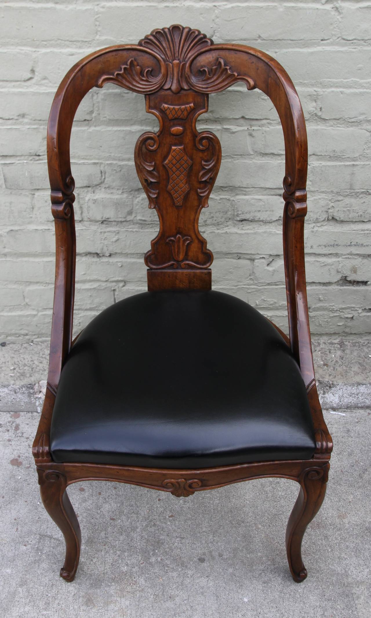 Set of (8) Italian carved regency style dining chairs with black leather seats.