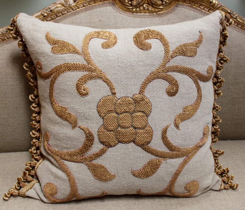 Pair of antique gold metallic appliqued home spun linen pillows with tassel fringe @ sides.  Down inserts, sewn shut.