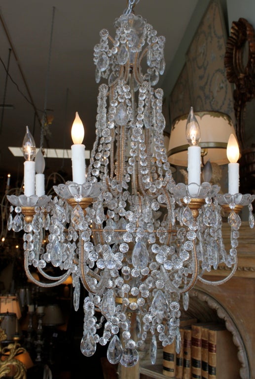Eight-light Italian crystal beaded chandelier adorned with garlands of crystals beads and almond crystal drops throughout. Wood gold leaf bobeches with crystal candle cups. Drip wax candle covers. This fixture has been newly wired with chain and