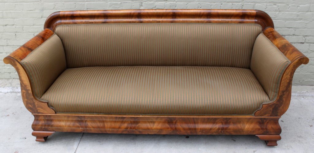 19th century Flame Mahogany veneer America Empire Sofa with new striped upholstery.