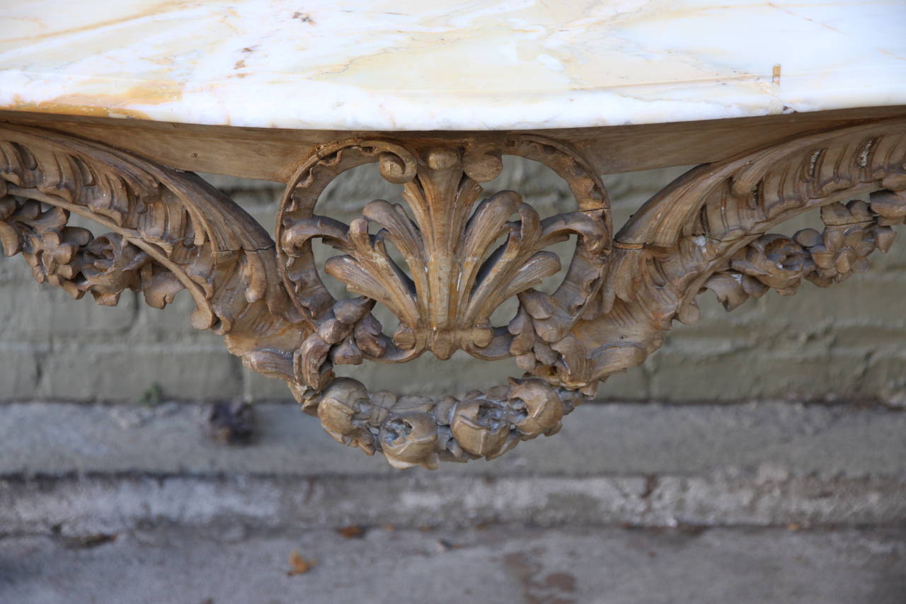 French Louis XV style carved console with onyx top. Console has intricate carved garlands of flowers, acanthus leaves and stands on four cabriole legs.
