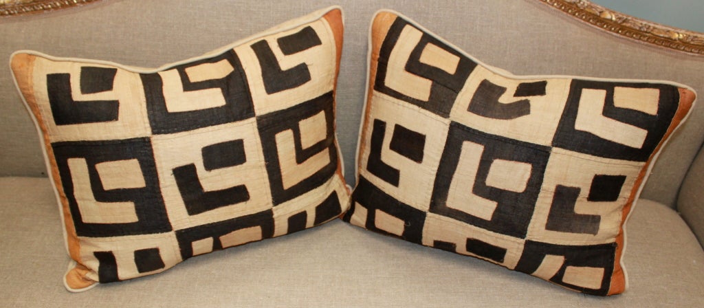 Pair of vintage Kuba Cloth pillows with linen backs and self cording. Down & feather inserts.