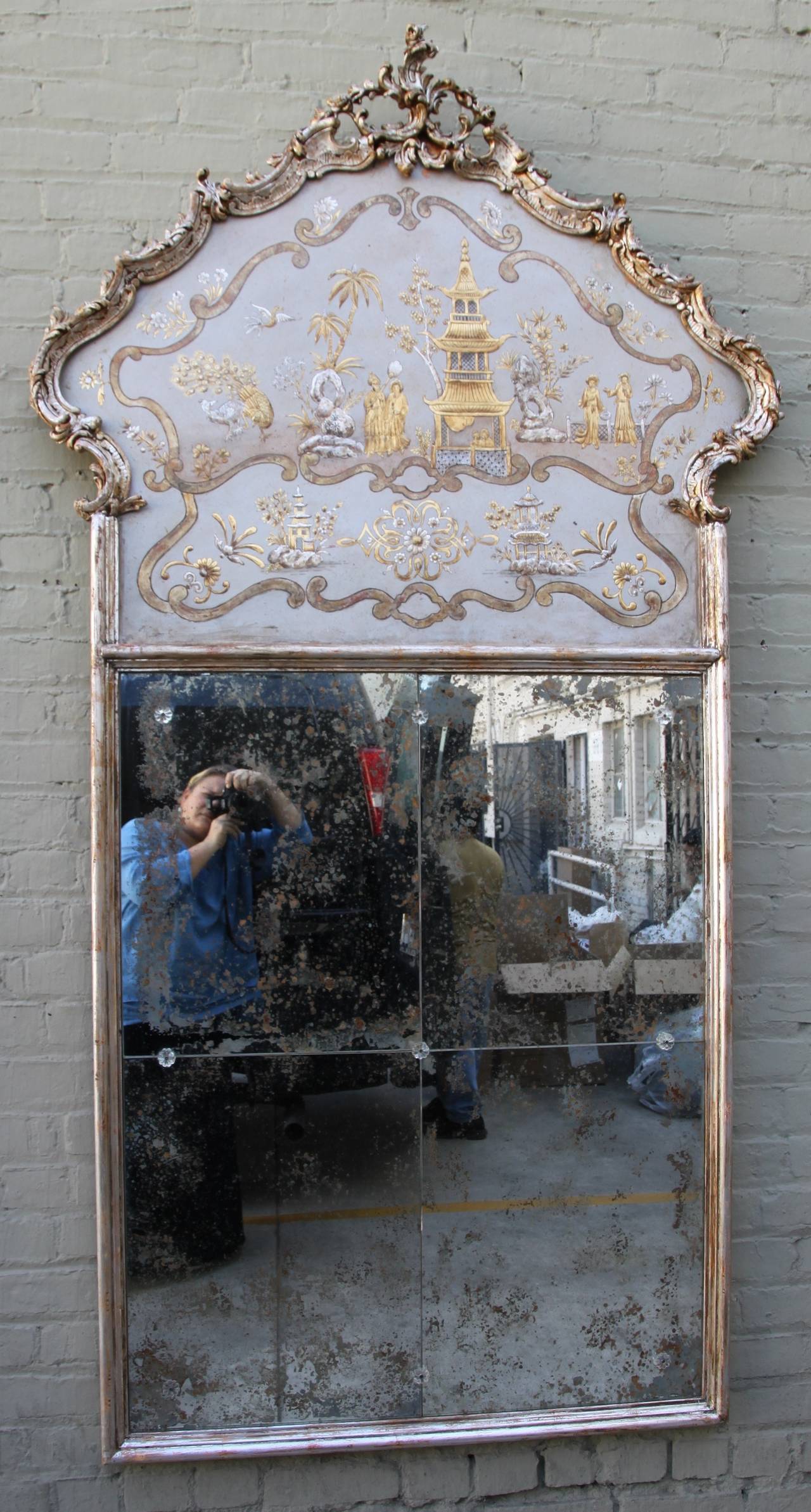 Pair of monumental scaled Italian gold and silver chinoiserie painted mirrors with antiqued mirror sectioned in four pieces and connected with crystal rosettes.