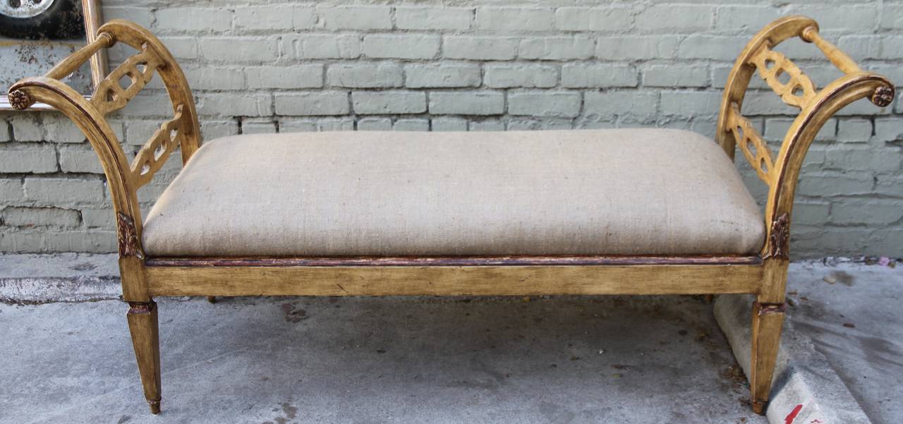 Italian style painted and parcel-gilt bench newly upholstered in burlap textile.