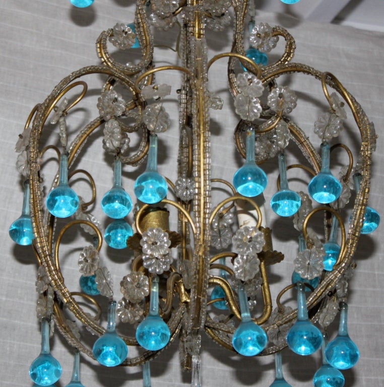 Italian aqua blue crystal beaded chandelier with gilt metal frame and clear crystal rosettes and bottom crystal drop.