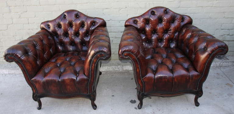 Pair of French leather tufted armchairs with walnut cabriole legs and nailhead trim detail.