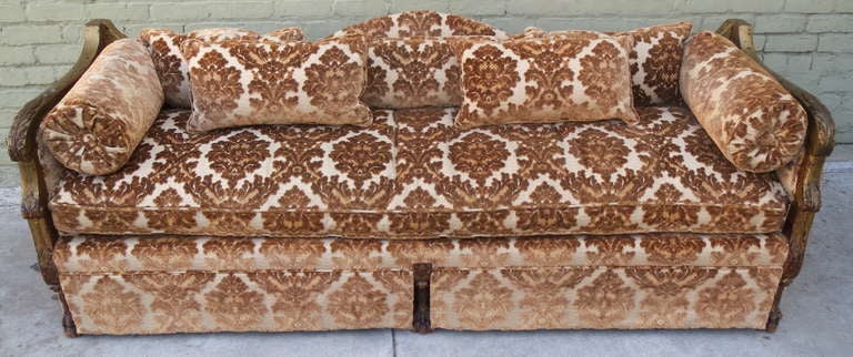 Carved Italian giltwood sofa upholstered in bronze colored cut velvet. Sofa has loose seat cushion, pair of bolsters, and three kidney back pillows. Carved paw feet.