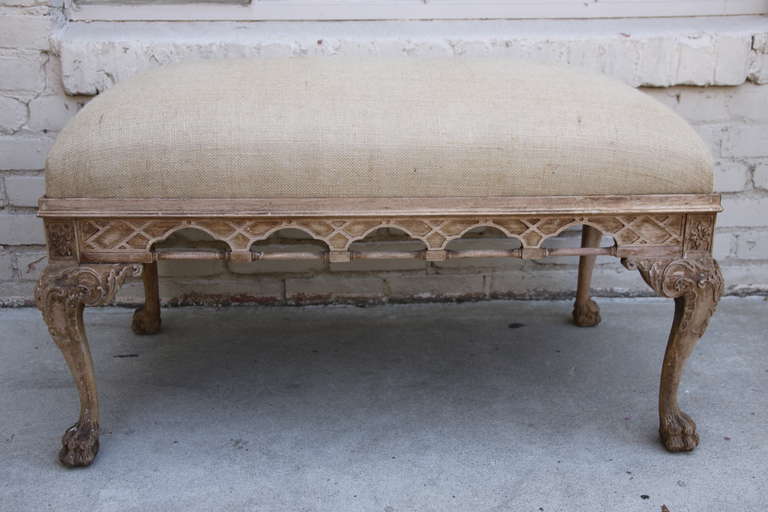 English Chippendale carved bench standing on four paw feet.  The bench is newly upholstered in burlap upholstery.
