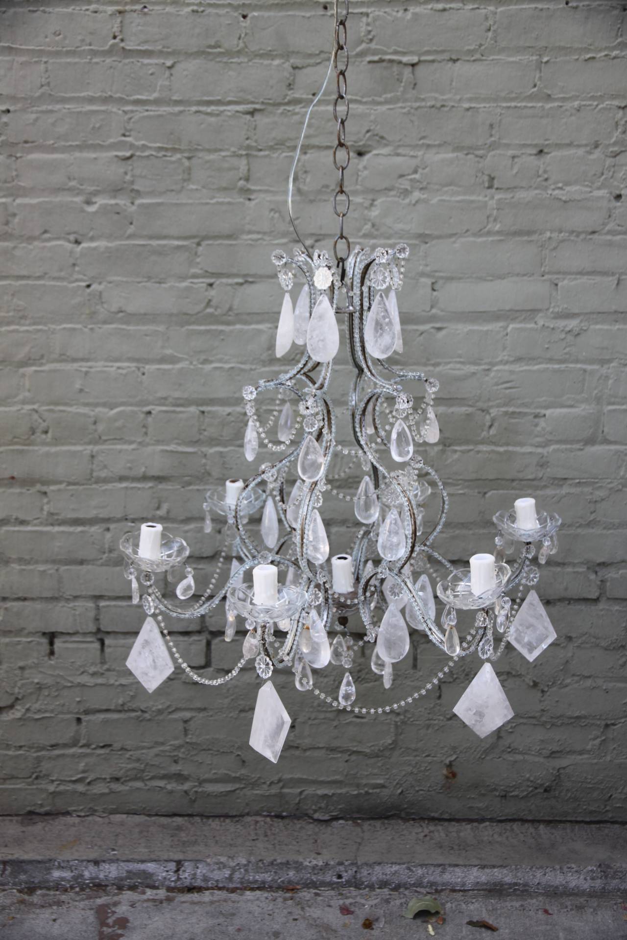 Eight-light rock crystal beaded arm chandelier with wax candle covers. English cut beaded garlands throughout. Newly wired and in working condition. Includes chain and canopy.