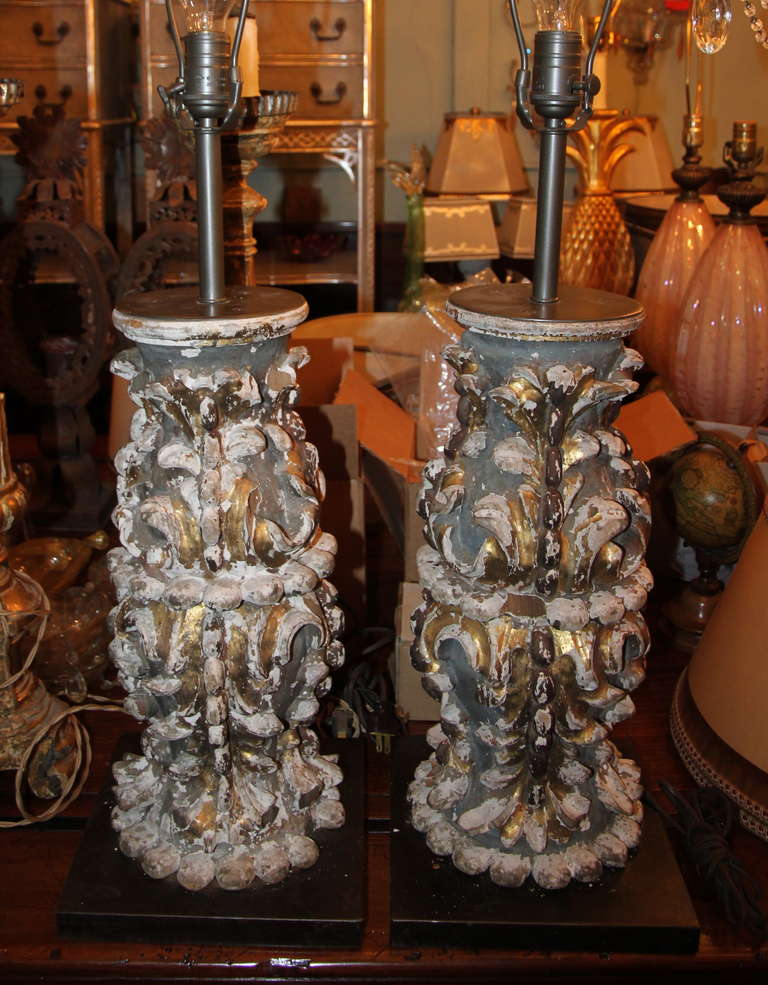 19th century painted & parcel gilt carvings wired into lamps on steel bases.