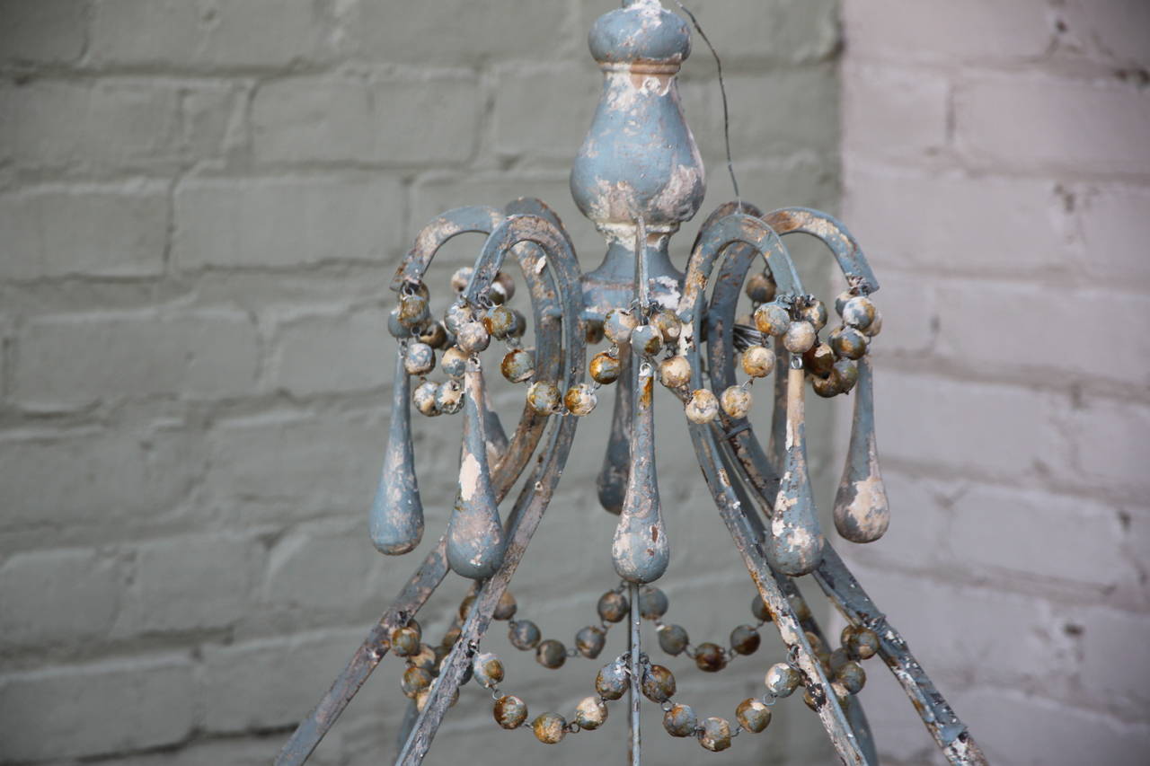 Iron and wood beaded eight-light painted chandelier with painted drops throughout. Newly wired and in working condition. Chain and canopy included.